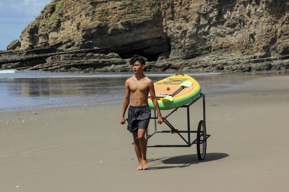 Costa Dulce surf instructor bringing surfboards out to the beach